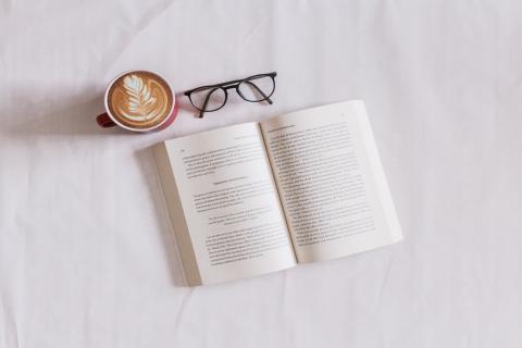 Picture of a coffee, glasses and a book